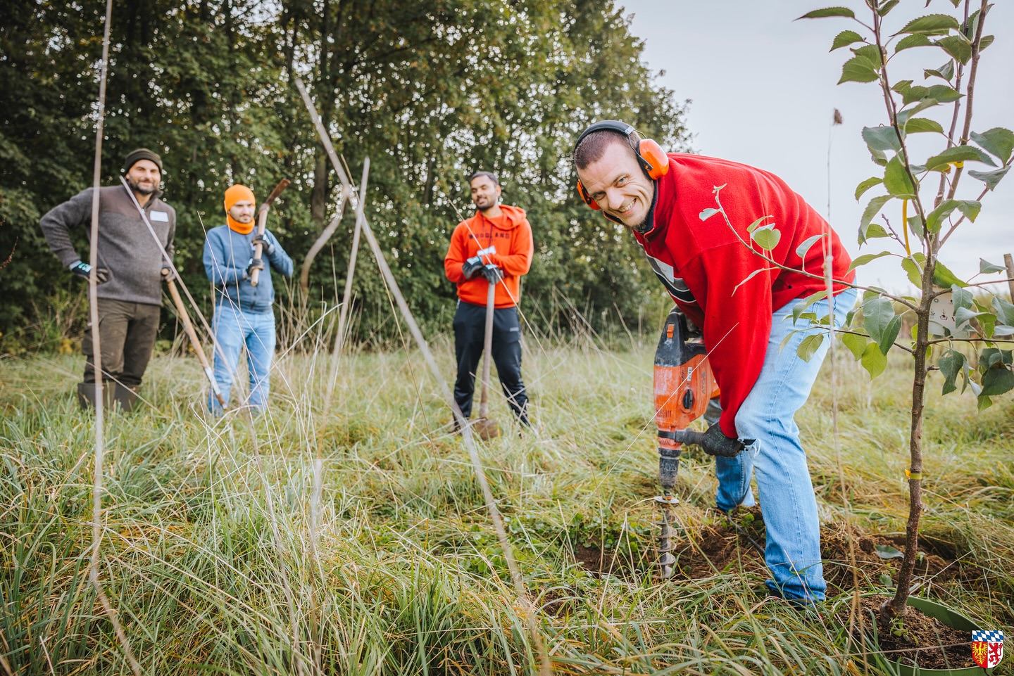 Vier Personen mit Gartenwerkzeugen auf der Streuobstwiese
